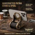 Uebnzns handcrafted patina phone stand and cable spool desk organizer holding a smartphone